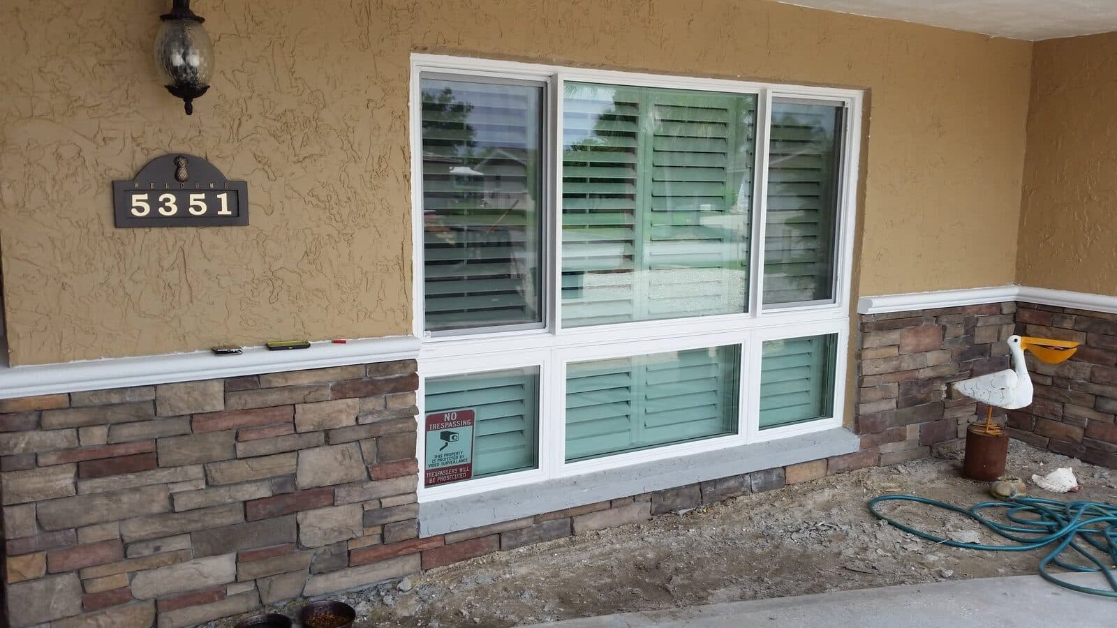 New white-frame replacement windows on a stone-accent New Port Richey home
